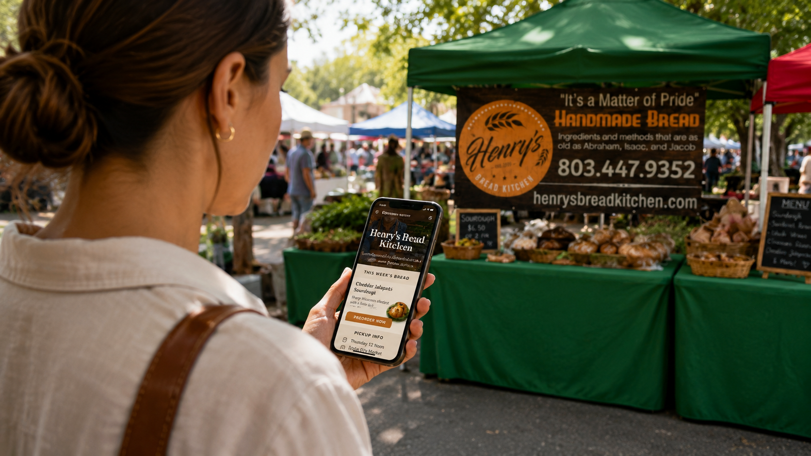 A customer checking a bakery storefront on her phone at a market booth